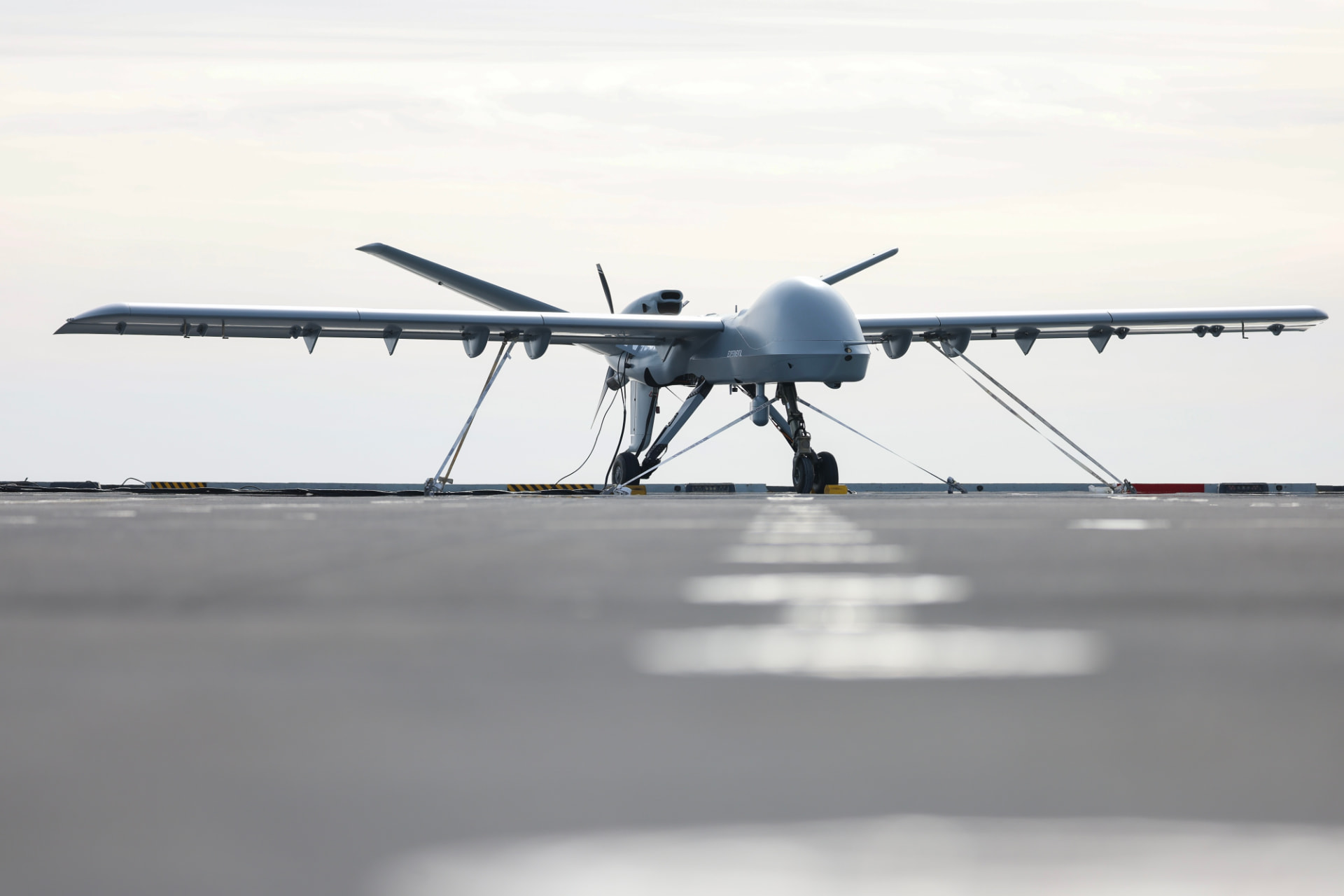Uncrewed fixed-wing aircraft positioned on an airfield.